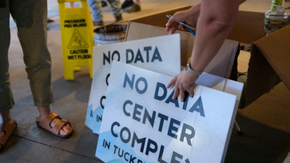Volunteers hand out anti-data center signs at a public meeting in Canaan Valley, West Virginia, June 30, 2025