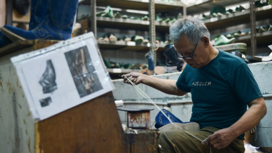 An artisan works on a pair of leather boots for the US market at the workshop of Tegep Boots