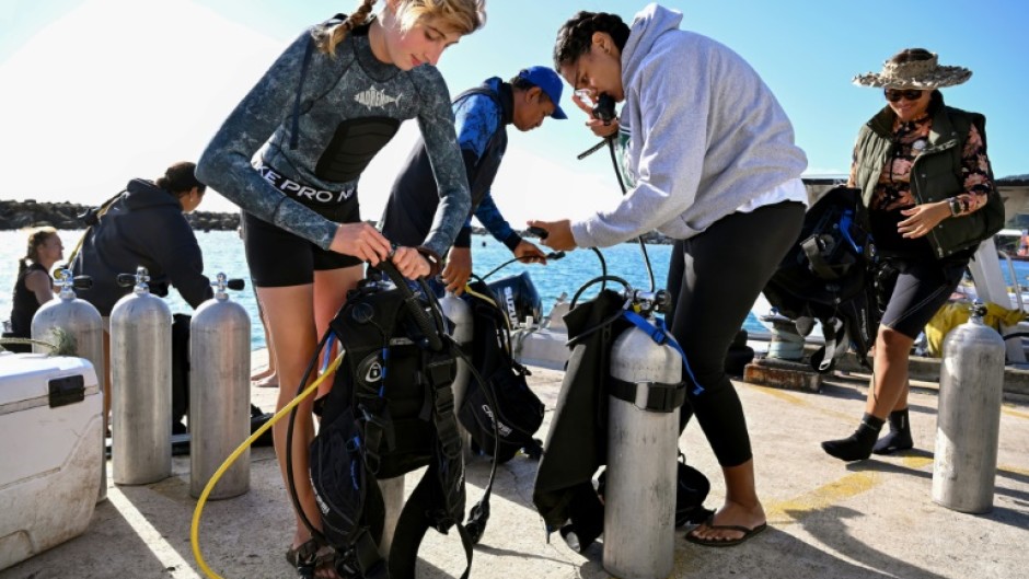 Divers from the environmental group Korero O Te Orau preparing their gear before collecting crown-of-thorns starfish from a reef off Rarotonga in the Cook Islands