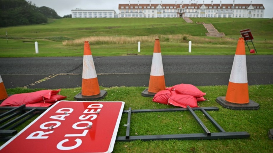 A 'Road Closed' sign is pictured laid on the verge of a road outside the Trump Turnberry hotel