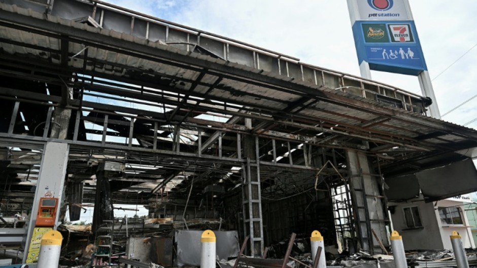 Damage from a fire caused by Cambodian artillery at a 7-11 convenience store is seen at a gas station in the Thai border province of Sisaket