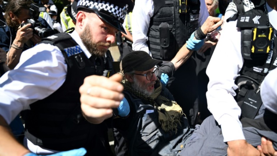 British police moving in on a small group of protesters displaying signs supporting Palestine Action