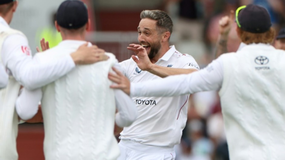 England's Chris Woakes (C) celebrates with team-mates after dismissing Sai Sudharsan in the fourth Test against India at Old Trafford