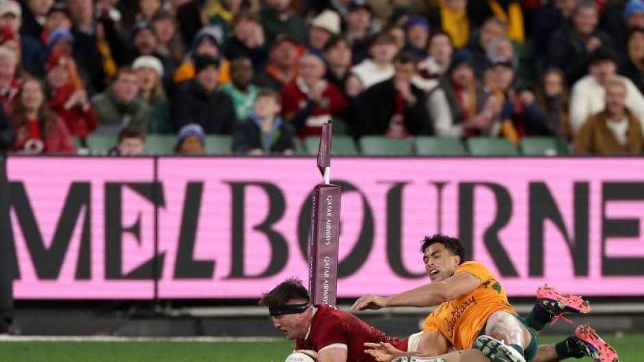 British and Irish Lions' Tom Curry scores a try under pressure from Australia's Joseph-Aukuso Suaalii