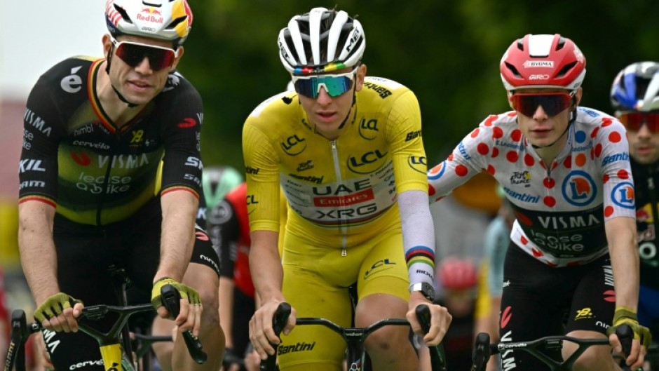 Team Visma riders Wout van Aert (L) and Jonas Vingegaard congratulate Tadej Pogacar at the end of stage 20