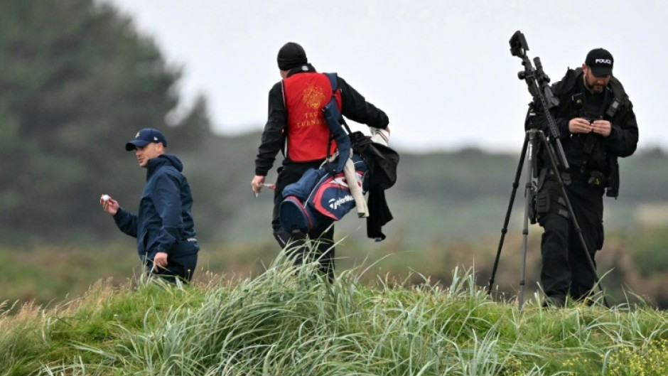 Golfers look for a ball in the rough as snipers and security personnel inspect the area before Trump played another round at his Trump Turnberry Golf Courses, ahead of a key meeting with the EU chief