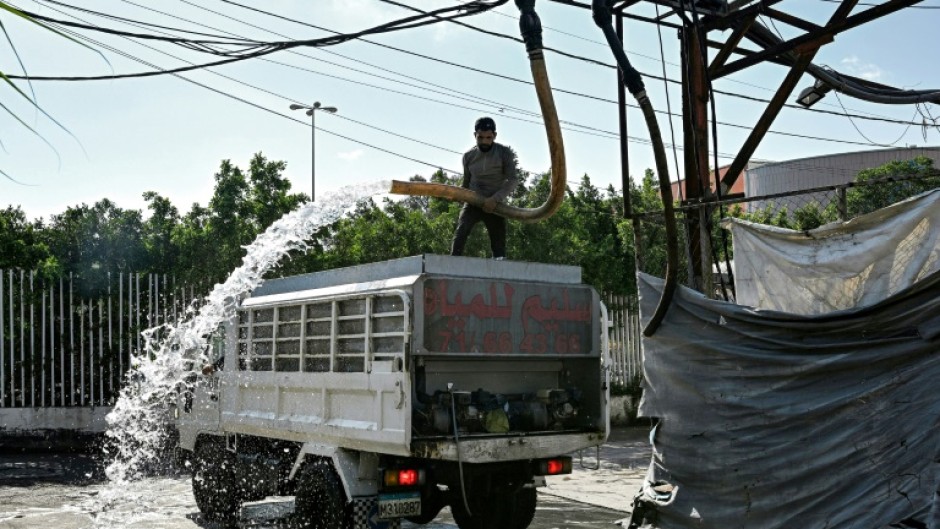 A man fills a delivery truck with water at a distribution facility in Beirut, where record-low rainfall is exacerbating pressure on the state water supply