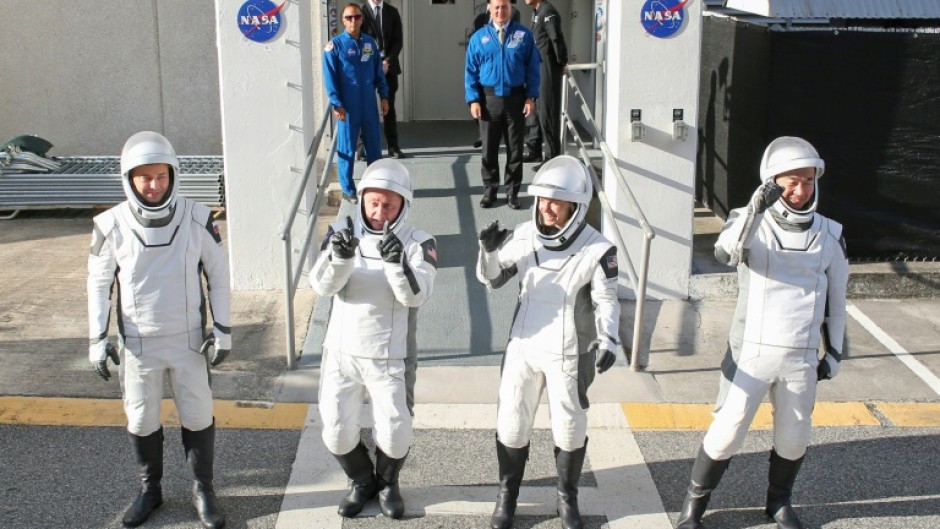 Crew-11 mission astronauts pause outside the Neil A. Armstrong Operations and Checkout Building en route to launch complex LC-39A at the Kennedy Space Center in Cape Canaveral, Florida on August 1, 2025