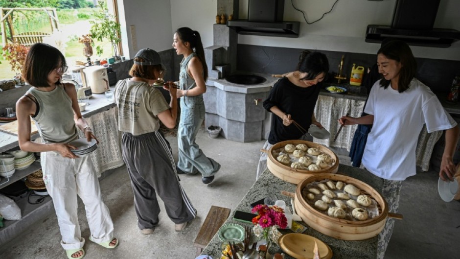 Chen Yani (R) eats lunch with friends and guests at her women's co-living space 'Keke's Imaginative Space' in Hangzhou