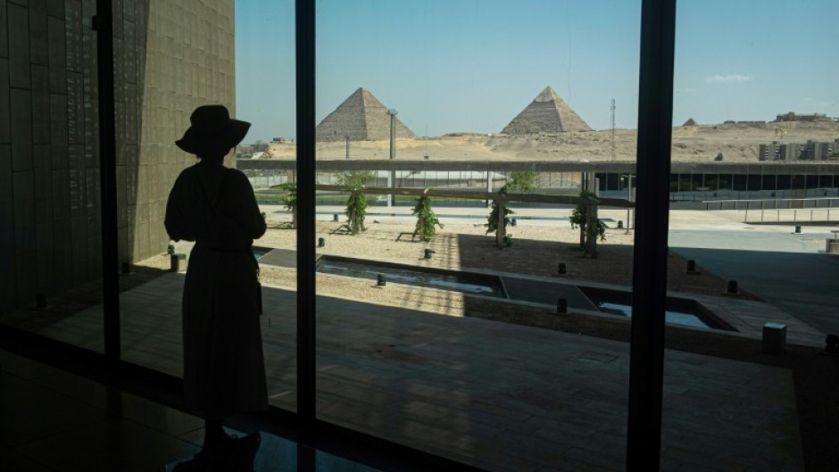 A visitor looks out towards the Giza pyramid complex as she tours the Grand Egyptian Museum in Giza on the southwestern outskirts of the capital Cairo on May 5, 2025