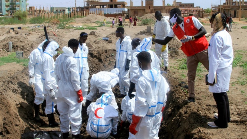 Red Crescent volunteers exhume Khartoum's war dead from makeshift plots where they were buried during the fighting so their families can give them a proper funeral