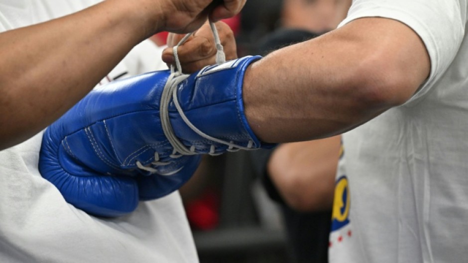 File picture of a trainer lacing up the gloves of Filipino boxer Manny Pacquiao