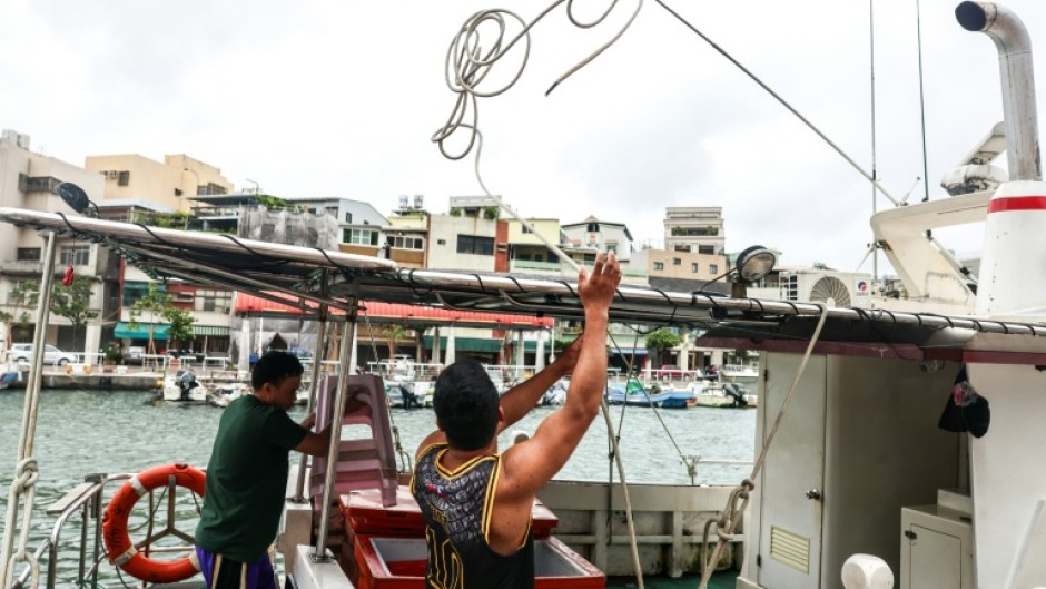 Fishermen secure their boat as Typhoon Podul approaches Taiwan on Wednesday