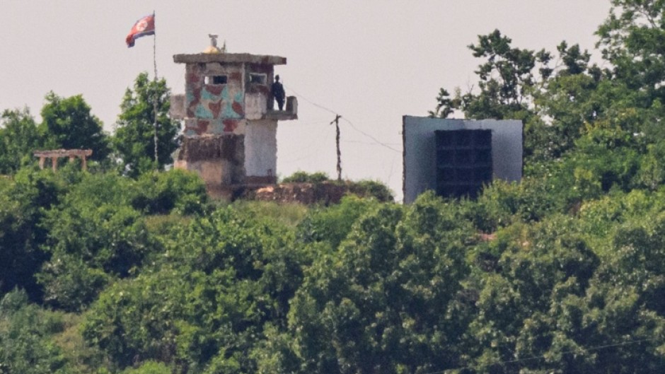 A North Korean soldier stands guard in a watch tower next to a giant loudspeaker near the Demilitarized Zone (DMZ) dividing the two Koreas in June