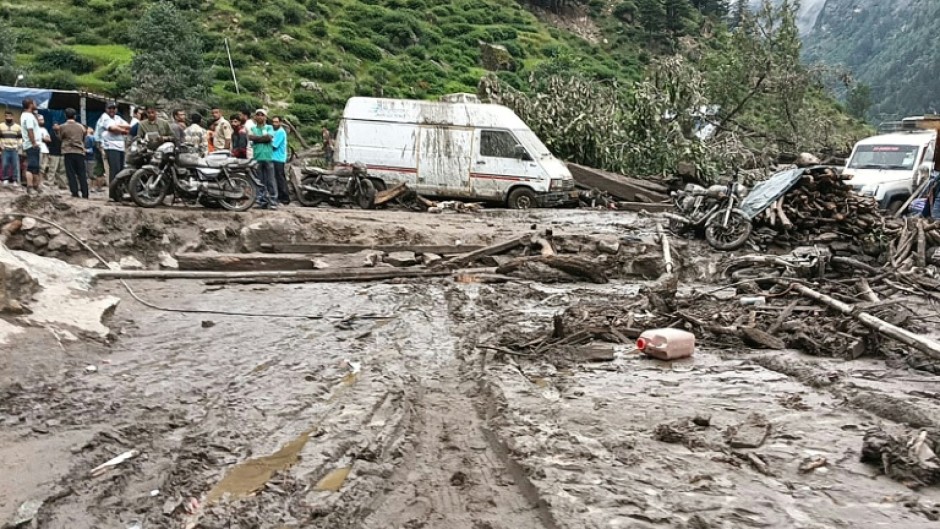 Rescuers inspect the site of a flash flood that has killed at least 60
