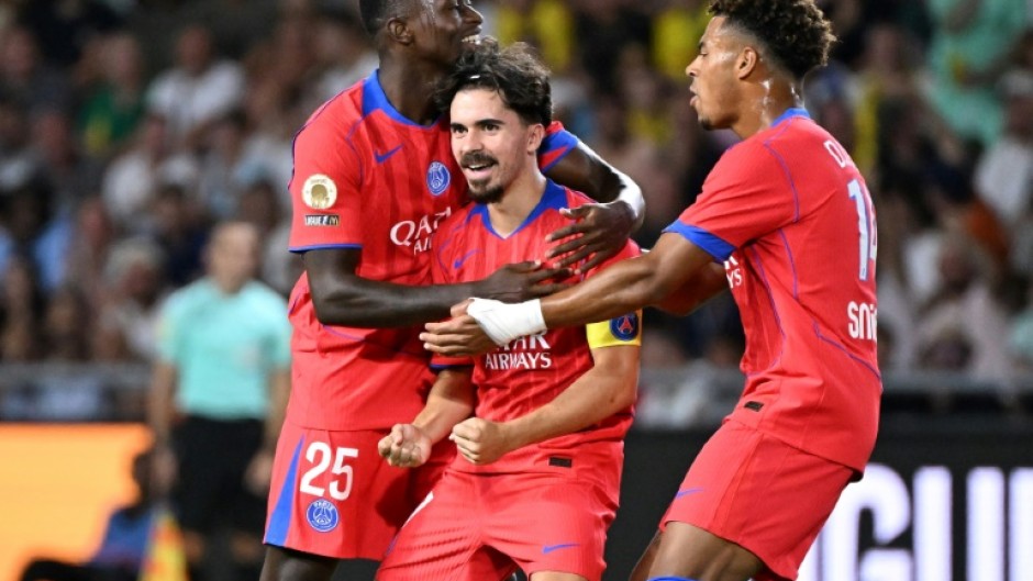 Vitinha (C) celebrates with teammates Nuno Mendes and Desire Doue after scoring Paris Saint-Germain's winning goal against Nantes