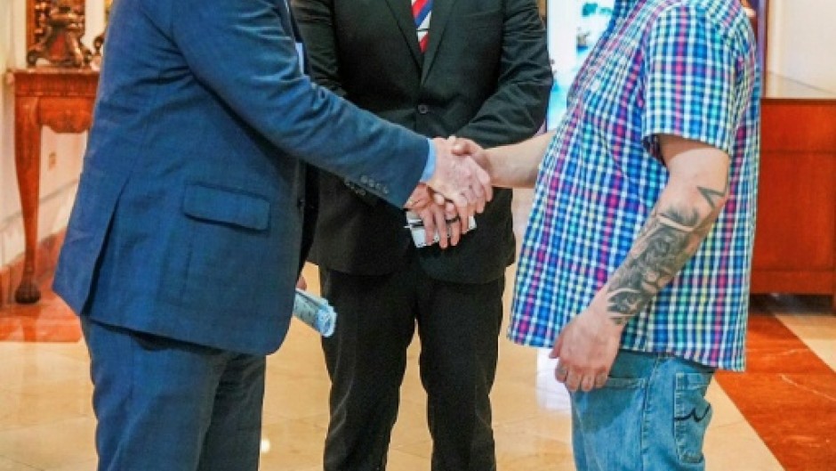 US Senator Chris Van Hollen (L) shakes hands with Salvadoran migrant Kilmar Abrego Garcia (R), a US resident wrongfully deported to his home country, at a hotel in San Salvador