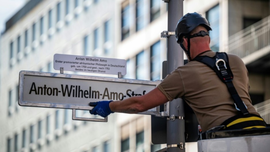 A worker installs a sign with the street's new name, after years of controversy and a last-minute courtroom drama over the old name, 'Moors' Street'