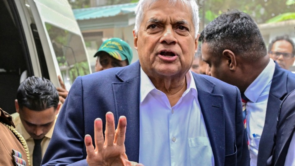 Sri Lanka's former president Ranil Wickremesinghe gestures as he arrives to appear before a court after his arrest