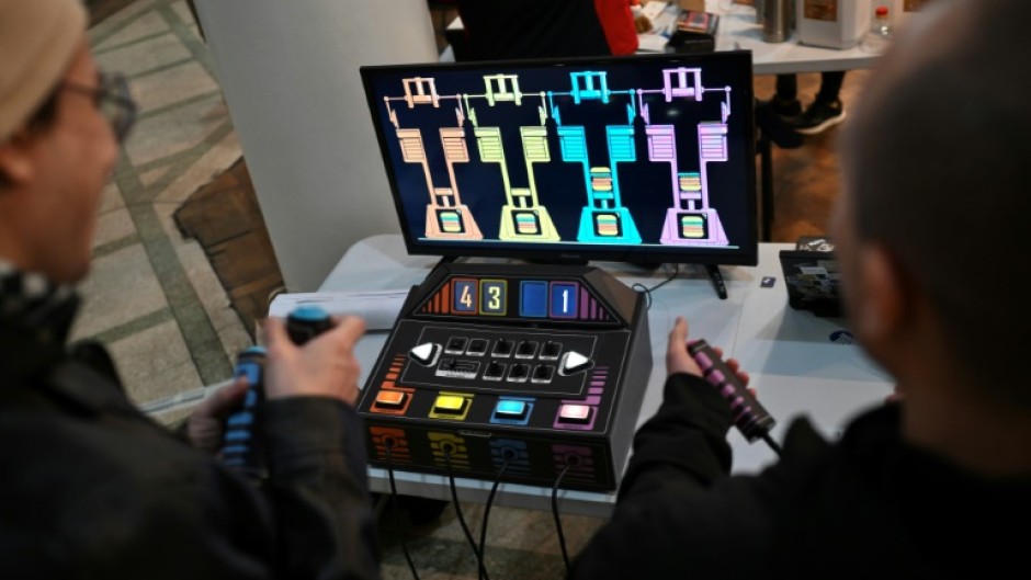 Men play a video game made from used and recycled electronic components during the 3rd Federal Cyberciruja Meeting in Buenos Aires