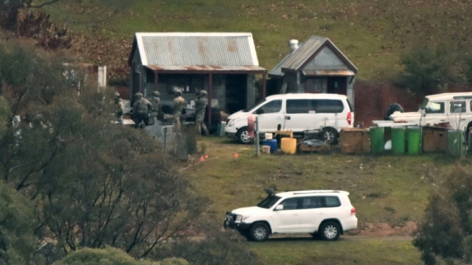 Australian police searched buildings for a gunman suspected of killing two officers