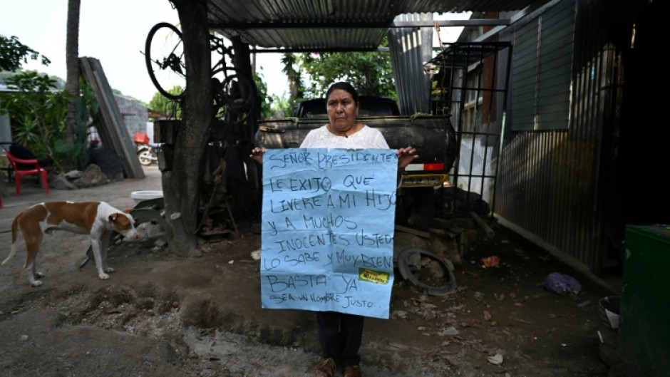 Juana Fuentes, 54, holds a sign addressed to President Nayib Bukele calling for the release of her son Nelson Antonio Fuentes, 23, imprisoned since April 2022