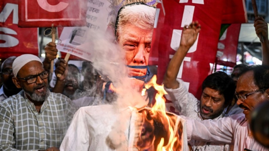 Activists burn an effigy of Trump to protest against tariff hikes during a demonstration in Kolkata