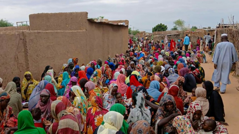 Sudanese residents gather to receive free meals in El-Fasher, a city besieged by Sudan's paramilitary Rapid Support Forces (RSF) for more than a year, in thr Darfur region