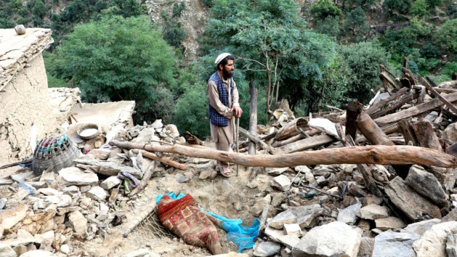 A man stahnds in the rubble of his quake -shattered home in Nurgal, Eastern Afghanistan, on September 4