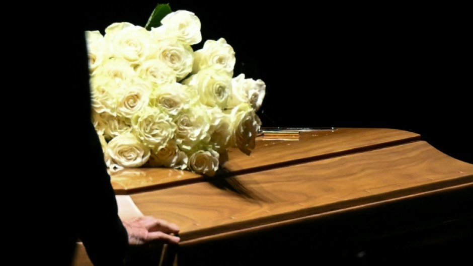 The coffin was laid in a darkened room, surrounded by white paper lanterns