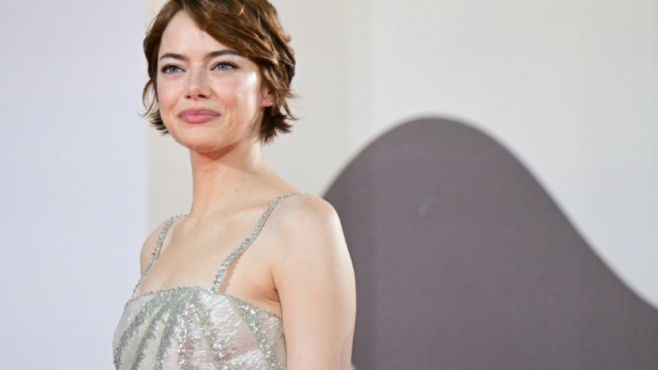 Emma Stone poses on the red carpet before the premiere of 'Bugonia'
