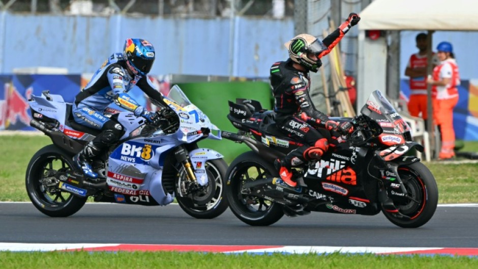 Aprilia Racing team's Italian MotoGP rider Marco Bezzecchi (R) celebrates after winning the San Marino Moto GP Sprint Race