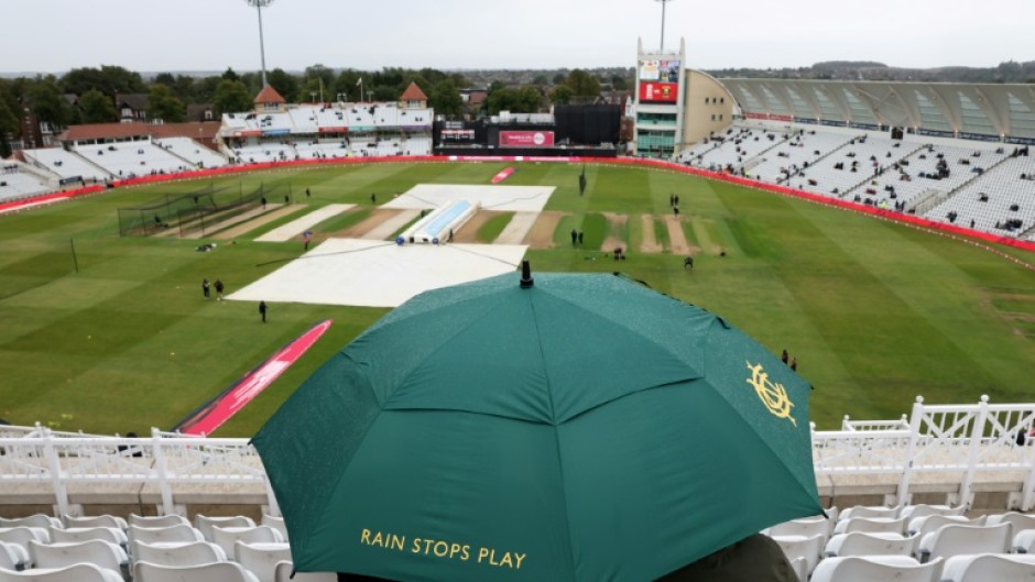 A spectators sits under an umbrella as rain washes out the third T20 between England and South Africa at Trent Bridge without a ball being bowled