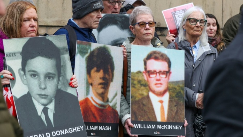 Relatives gathered outside the court bearing posters of those killed on Bloody Sunday