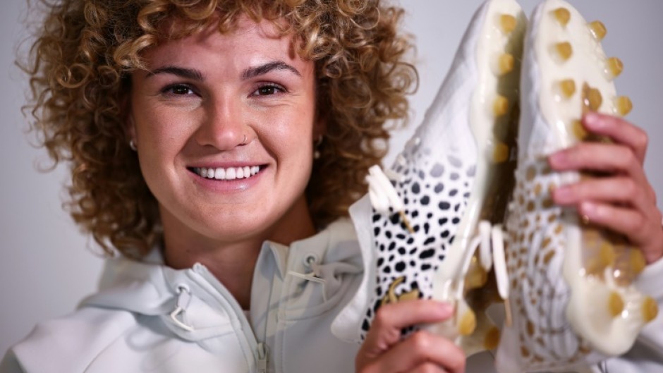 England's Ellie Kildunne poses with the boots she helped design and will wear in a Women's Rugby World Cup semi-final against France