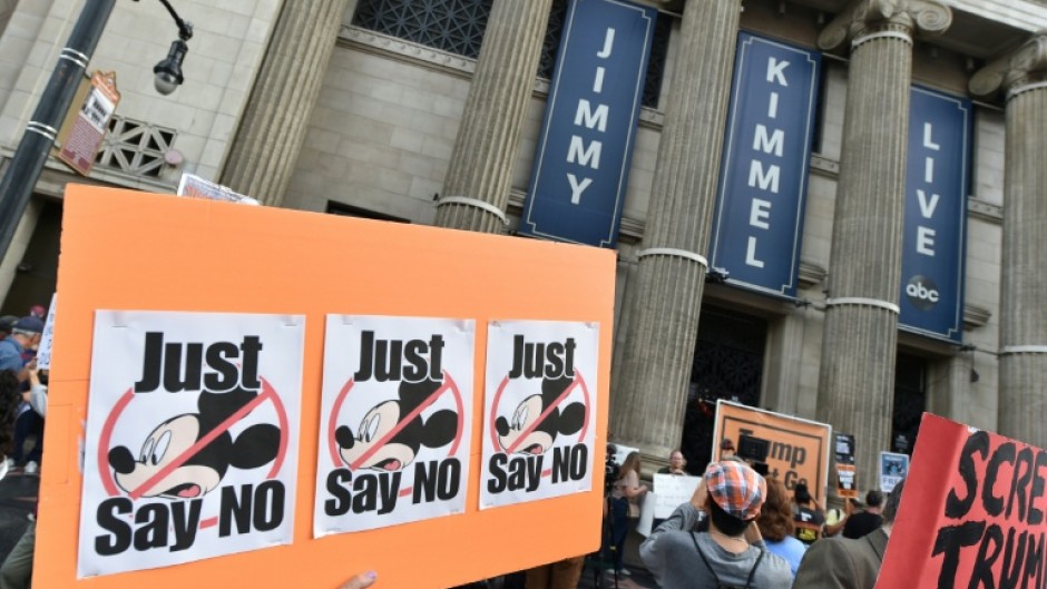 Demonstrators hold signs as they rally to protest the cancelation of the "Jimmy Kimmel Live!" show outside the El Capitan Entertainment Centre on Hollywood Boulevard, from where the show is broadcast in Hollywood, California