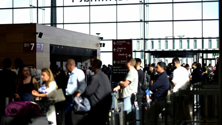Passengers queue for check-in at Terminal 1 of Berlin Brandenburg BER Airport Willy-Brandt in Schoenefeld, southeast of Berlin, after major European airports were hit by a cyberattack