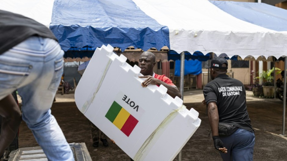 A worker loads voting booths into a pickup truck in Conakry on the eve of the country's constitutional referendum
