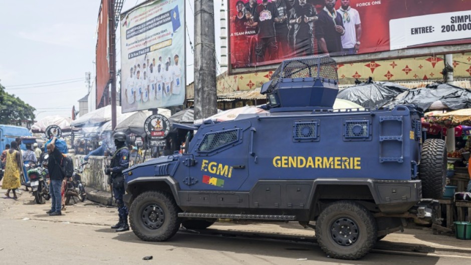 A gendarme stands guard next to an armoured vehicle in Conakry ahead of Guinea's constitutional referendum