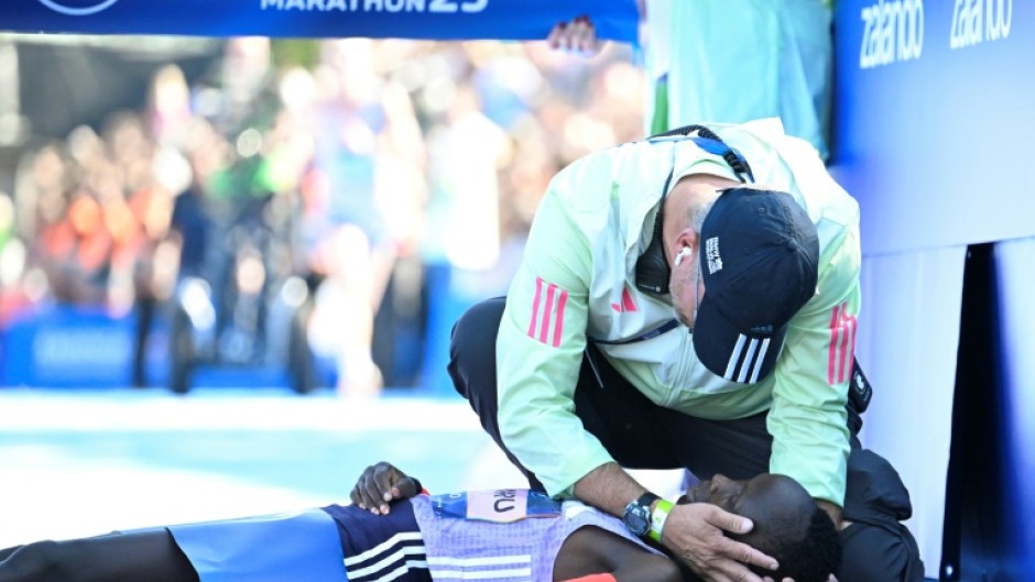 Kenya's Rosemary Wanjiru is tended to by a helper, having collapsed after crossing the finish line first.