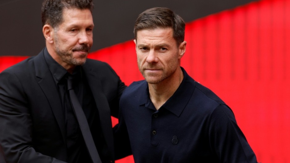 Real Madrid's Spanish coach Xabi Alonso (R) admitted his team deserved to lose the derby clash against Atletico Madrid led by Diego Simeone (L)