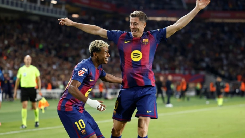 Barcelona's Polish forward Robert Lewandowski celebrates with Lamine Yamal after the winger set him up to score against Real Sociedad