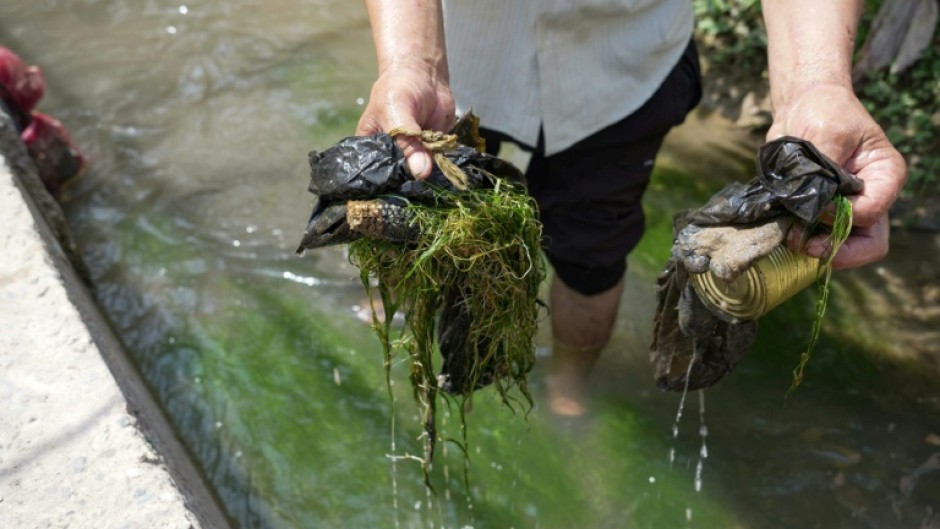 Tajik labourer Nematoullo Bassirov shows garbage he scooped from the stream running through his yard mountainous Central Asian country. "It contains all sorts of dirt," Bassirov tells AFP, as he cleans the small irrigation canal used by the entire village in the Balkh district.