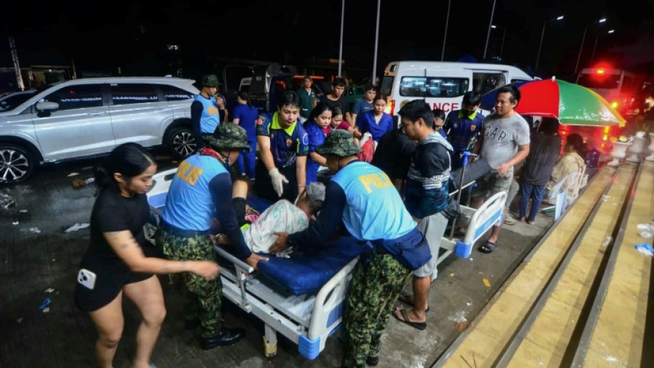 Police assist injured residents as they are brought to the hospital in Bogo City, Cebu province, central Philippines