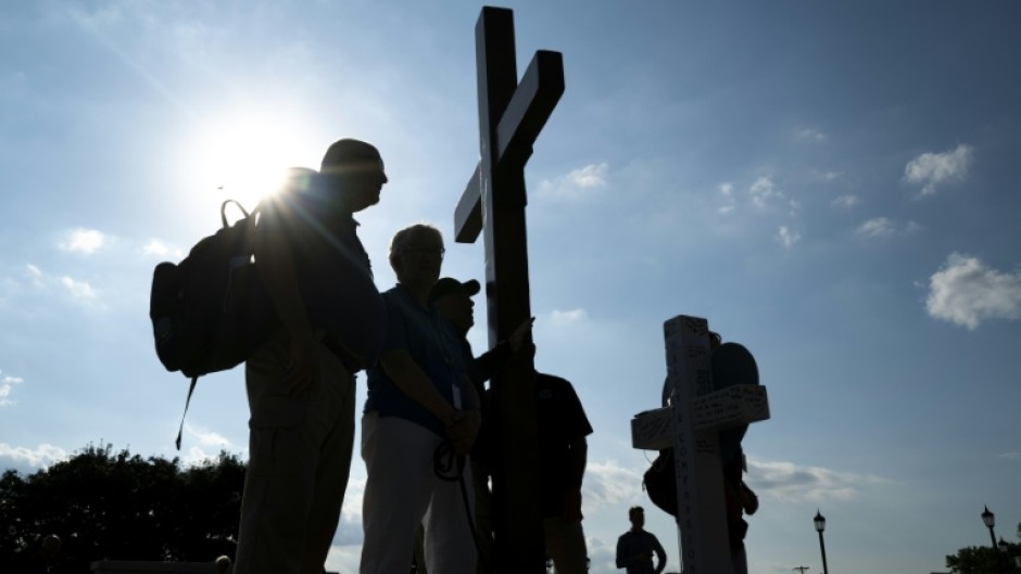 People gather outside an interfaith service at the Basilica of Saint Mary in Minneapolis, Minnesota, following a mass shooting at a local Catholic school in August 2025