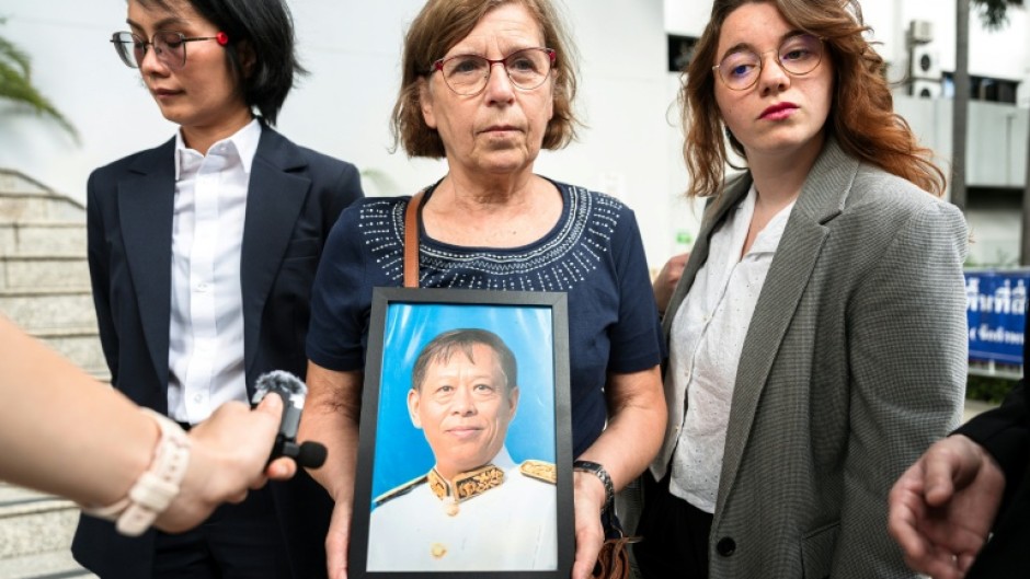 The trial began just three days ago with an examination of witnesses, including Lim Kimya's widow, Anne-Marie Lim (centre, holding a photo of Lim Kimya)