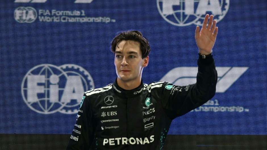 Mercedes' British driver George Russell waves as he celebrates getting pole position