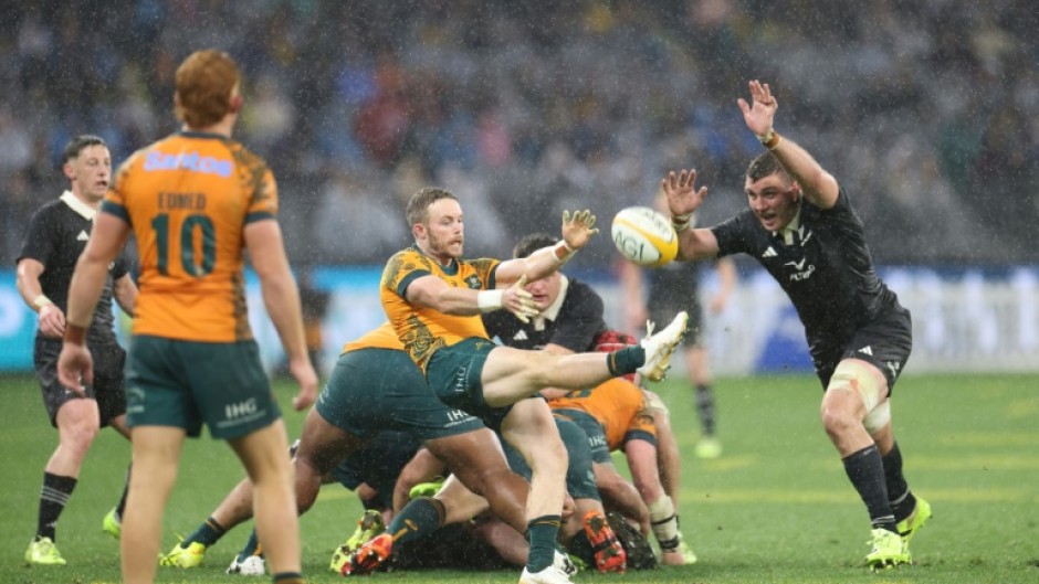 New Zealand defeated Australia 28-14 in wet conditions in Perth to keep their Rugby Championship title hopes alive