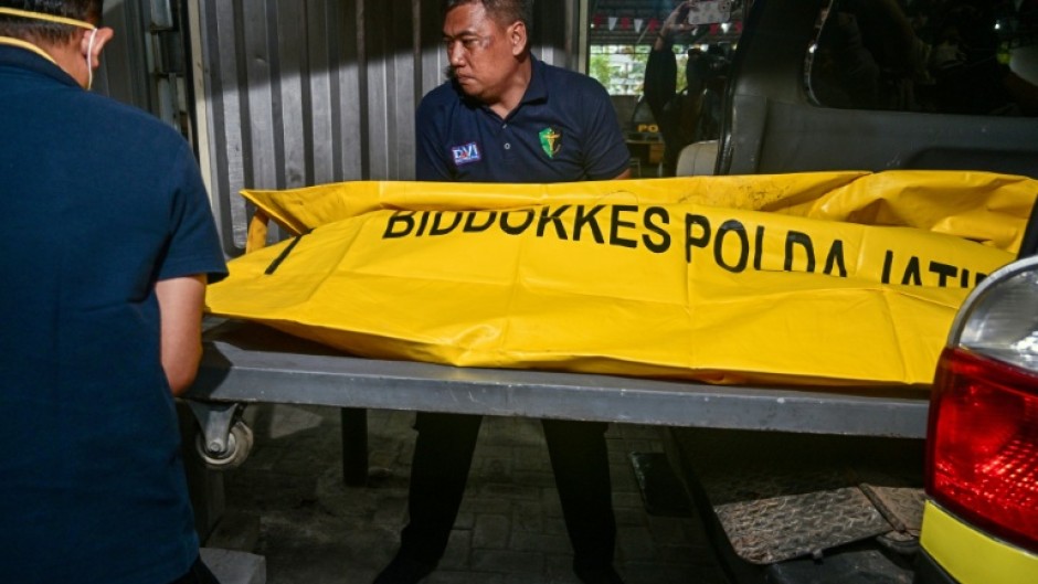 Police officials transfer the remains of a student, killed in the collapse at a boarding school on Indonesia's Java island
