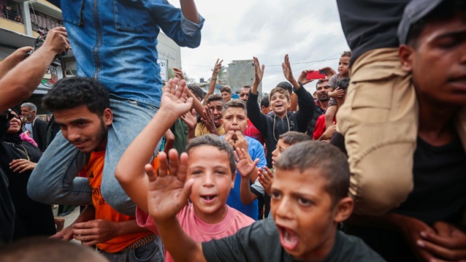 Palestinian children celebrate in Khan Yunis on October 9, 2025, following news of a new Gaza ceasefire deal